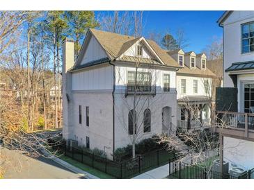 Modern three-story home with white brick exterior and a metal roof at 160 Cricket Ln, Alpharetta, GA 30009