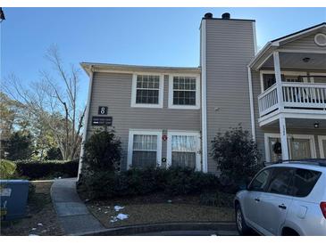 Two-story condo building with gray siding, balconies, and parking at 1345 Keys Crossing Ne Dr # 1345, Atlanta, GA 30319