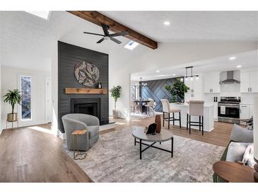 Open-concept living room featuring a fireplace, modern decor, and seamless flow into the kitchen at 2645 Shadow Woods Ne Cir, Marietta, GA 30062
