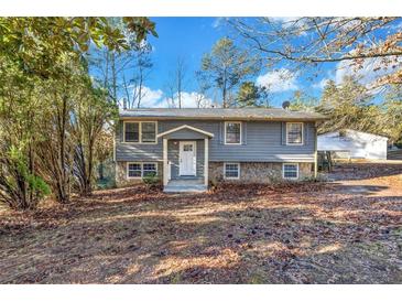 Gray house with stone accents, welcoming front entrance, and landscaping at 2234 Cherokee Valley Dr, Lithonia, GA 30058