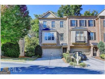 Attractive three-story townhome with two-car garage and manicured landscaping at 2790 Laurel Valley Trail, Buford, GA 30519