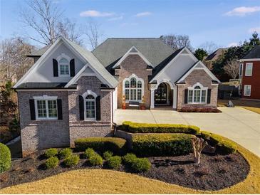 Brick home with landscaping, large driveway, and three-car garage at 5008 Cambridge Ln, Villa Rica, GA 30180