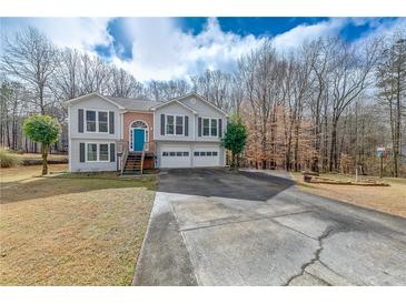 Charming split-level home featuring a two-car garage, blue front door, and a spacious driveway at 2205 Castle Royale Dr, Lawrenceville, GA 30043