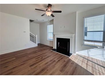 Bright living room featuring hardwood floors, fireplace, and large windows at 1814 Emory Ln # 92, Conyers, GA 30013