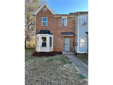 Brick townhouse with bay window and landscaped yard at 774 Crestside Ct, Austell, GA 30168