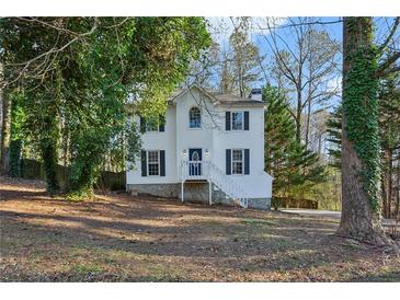 Two-story house with white siding, blue door, and a tree-lined yard at 1741 Charrington Way, Powder Springs, GA 30127