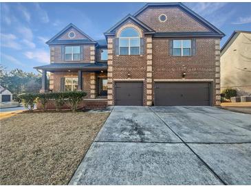 Brick two-story house with a three-car garage and landscaping at 8372 Members Dr, Jonesboro, GA 30236