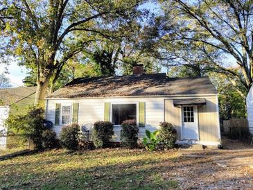 Charming white house with green bushes and mature trees at 708 South Ave, Forest Park, GA 30297