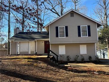 Two-story house with a red door and black shutters, nestled on a wooded lot at 5449 Martins Crossing Rd, Stone Mountain, GA 30088