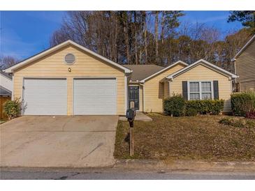 House exterior featuring a two-car garage and well-maintained lawn at 1363 Stoneleigh Way, Stone Mountain, GA 30088