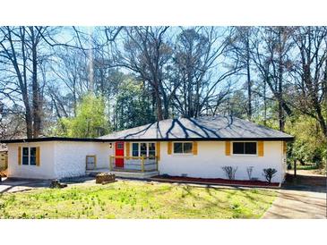 Charming ranch home with updated exterior, featuring a red door and landscaped lawn at 1807 W Austin Rd, Decatur, GA 30032