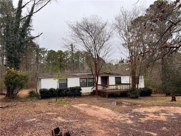 White mobile home with deck, surrounded by trees at 3520 Haynes Ridge Rd, Loganville, GA 30052