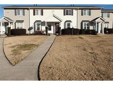 Tan siding townhouse with 2-car parking and manicured lawn at 1625 Conley Rd # 138, Conley, GA 30288