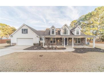 Two-story house with stone accents and a large yard at 910 Callee Dr, Loganville, GA 30052