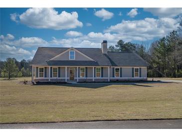 Charming ranch-style home featuring a welcoming front porch and well-maintained landscaping at 85 Woodfin Way, Social Circle, GA 30025