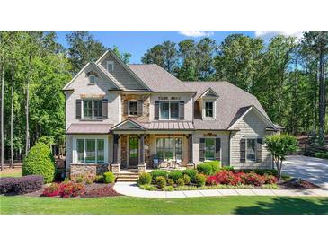 Charming two-story home boasts a manicured lawn, beautiful landscaping, and a welcoming front porch at 5330 Lake Redwine Nw Cv, Acworth, GA 30101