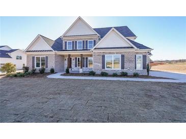Two-story brick home with gray shutters, a covered porch, and a landscaped yard at 5450 Crow Dr, Cumming, GA 30041