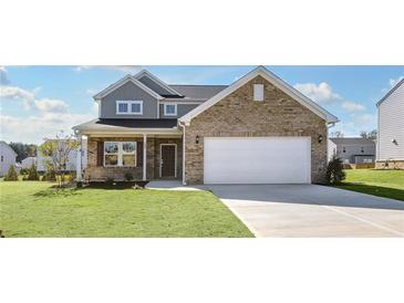 Two-story home with brick and siding exterior, two-car garage, and landscaped lawn at 509 Elkwood Ln, Mcdonough, GA 30252