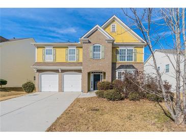 Brick and vinyl two-story home with a three-car garage and landscaping at 7336 Toccoa Cir, Union City, GA 30291