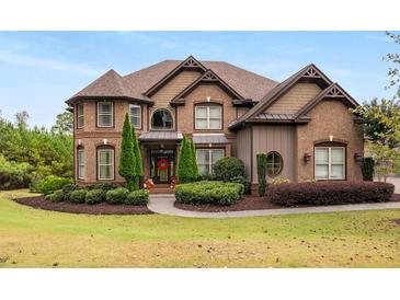 Brick house with a 3-car garage and lush landscaping at 580 Grimsby Ct, Suwanee, GA 30024