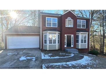 Brick two-story house with attached garage and landscaped yard at 710 Ridge Way, Lithonia, GA 30058