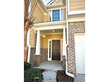 Inviting front entrance with brick accents and a charming covered porch at 307 Creek Manor Way, Suwanee, GA 30024