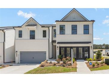 Two-story house with white brick exterior, gray garage door, and landscaping at 1944 Westwind Street (Lot 133), Lawrenceville, GA 30043