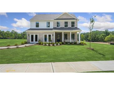 Two-story home with brick and siding, a front porch, and landscaped lawn at 165 Poppy St, Mcdonough, GA 30253