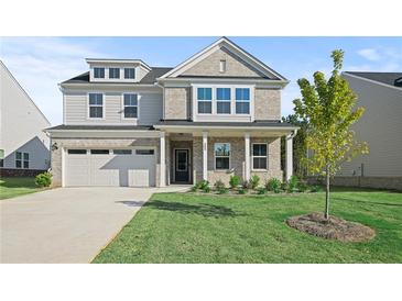 Two-story brick home with a large front yard and attached garage at 305 Foxglove Way, Mcdonough, GA 30253
