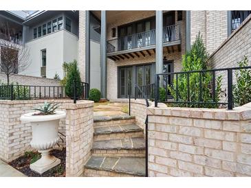 Stone steps lead to a patio with a brick wall and landscaping at 92 Sheridan Dr, Atlanta, GA 30305