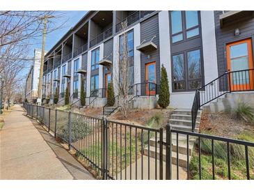 Modern townhouses with orange doors, black metal railings, and landscaped yards at 457 Parkway Ne Dr, Atlanta, GA 30308