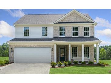 Two-story house with brick and siding, a white garage door, and a landscaped lawn at 344 Foxglove Way, Mcdonough, GA 30253