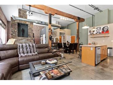 Expansive living room with a stone fireplace, exposed beams and ductwork, and an open floor plan at 350 Peters Sw St # 3, Atlanta, GA 30313