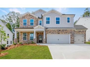 Two-story home with stone accents and a three-car garage at 715 Crossroad Ct, Powder Springs, GA 30127