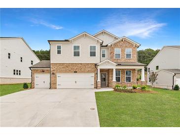 Beautiful two-story home with a stone and siding exterior, three-car garage, and a well-manicured lawn at 715 Crossroad Ct, Powder Springs, GA 30127
