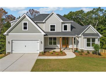 Two-story craftsman home with gray siding, a three-car garage, and a manicured lawn at 220 Autumn Brook Dr, Canton, GA 30115