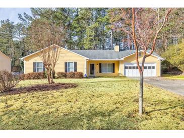 Ranch style home with yellow siding, attached garage, and landscaped yard at 1237 Torrey Pl, Dacula, GA 30019