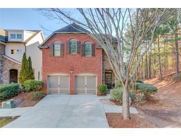 Brick front two-story home with two-car garage and landscaping at 588 Myrtle Trace Ln, Suwanee, GA 30024