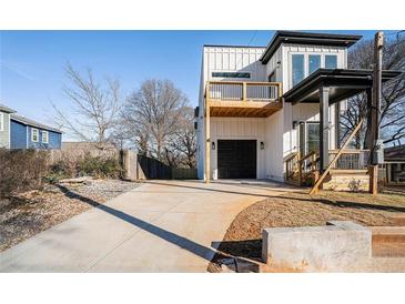 Two-story modern farmhouse with a balcony, driveway, and landscaped yard at 862 Hobson Sw St, Atlanta, GA 30310