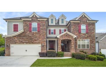 Two-story house with stone and shingle exterior,red shutters, and a three-car garage at 1622 Harvestwood Ct, Hoschton, GA 30548