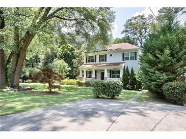 Two-story house with a light gray exterior, landscaped lawn, and a long driveway at 1648 Beacon Hill Ne Blvd, Atlanta, GA 30329