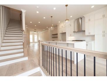 Bright open-plan kitchen features quartz countertops, modern appliances, pendant lighting, and beautiful hardwood floors at 550 Fisher Dr # 47, Alpharetta, GA 30009