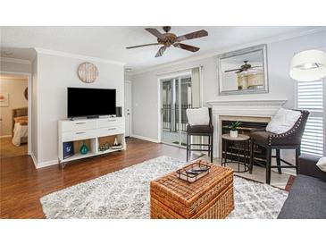 Bright living room with fireplace, hardwood floors, and sliding glass door to patio at 631 Granville Ct, Atlanta, GA 30328