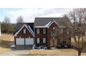 Brick two-story house with a two-car garage and mature trees at 12558 Lakeside Pkwy, Fayetteville, GA 30215