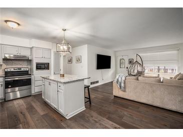 Open-concept kitchen with a center island and stainless steel appliances flows into the adjacent living area at 2725 Shoreland Sw Dr, Atlanta, GA 30331