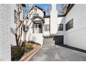 White brick townhouse exterior with attached garage and landscaping at 4196 Roswell Rd Ne, Atlanta, GA 30342