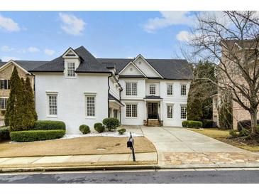 Stunning white brick home with a black roof, large windows, and a stone walkway at 745 Glengate Pl, Atlanta, GA 30328