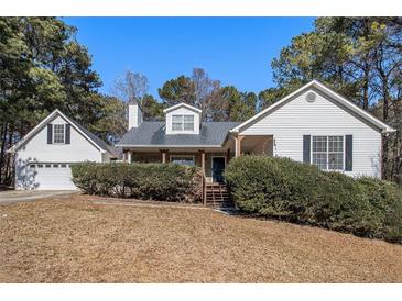 White house with a two-car garage and landscaping at 272 Mckenzie Dr, Stockbridge, GA 30281