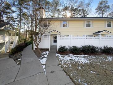 Inviting yellow house exterior with a white fence and walkway at 1612 Alexandria Se Ct, Marietta, GA 30067