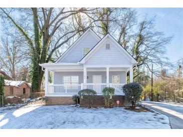 Charming light gray house with a front porch and snow-covered yard at 1156 Tucker Sw Pl, Atlanta, GA 30310